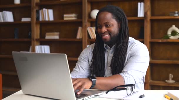 Um funcionário de escritório masculino afro-americano usando um laptop — Vídeo de Stock