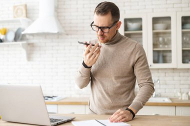 Zeki genç adam sesli mesaj kaydediyor.