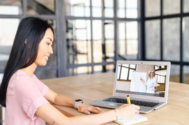 Genç Asyalı kadın internetten çalışıyor.