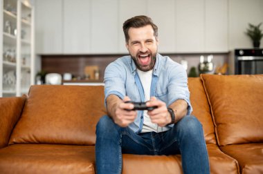 Genç sakallı hippi video oyunları oynuyor.