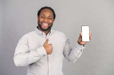 Elinde akıllı telefon tutan gülümseyen Afro-Amerikan adam gride izole edilmiş.