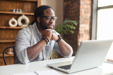 Düşünceli Afrikalı işadamı evdeki kabinesinde çalışıyor.