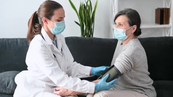 En sjuksköterska besöker en kvinnlig patient hemma — Stockvideo