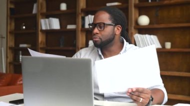 Genç Afrikalı Amerikalı çalışan evrak işleriyle uğraşıyor.