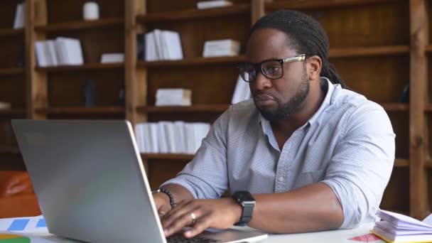 Εστιασμένος Αφροαμερικανός που κάνει διάλειμμα στο χώρο εργασίας — Αρχείο Βίντεο