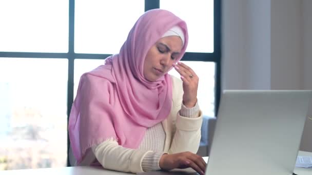 Moslim vrouw draagt hijab met behulp van laptop op kantoor — Stockvideo