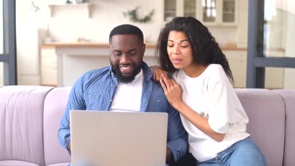 Feliz casal multirracial usando um laptop em casa — Vídeo de Stock