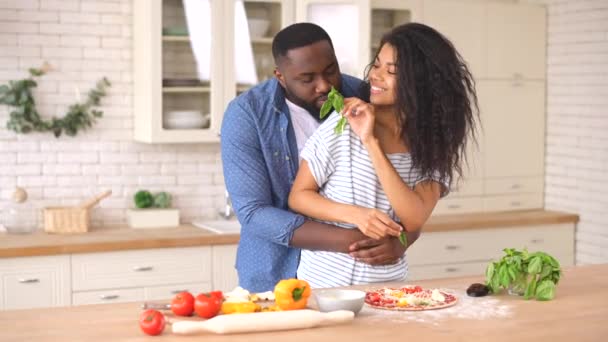 Feliz pareja multirracial preparando pizza juntos en casa — Vídeo de stock