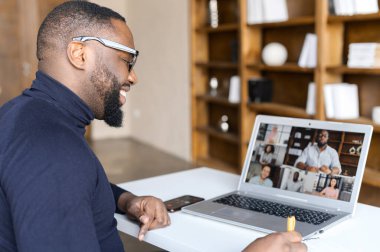 African-American guy using laptop for video call clipart