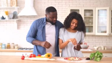 Mutlu çok ırklı çift evde pizza hazırlıyor.