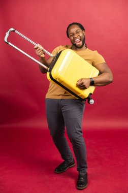 Kırmızı bavullu neşeli Afro-Amerikalı adam.