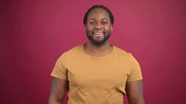 Kırmızı arka planda izole edilmiş neşeli Afro-Amerikalı adam.