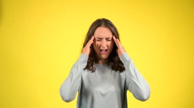 Çekici kıvırcık kadın baş ağrısının sarı renkte olduğunu hissediyor.