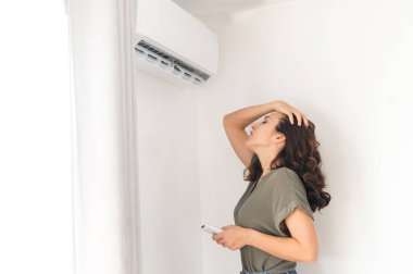 Çekici kıvırcık kadın klimayı açıyor.