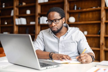 E-öğrenme konsepti, gündelik Afrikalı Amerikalı iş adamı deftere yazı yazıyor.