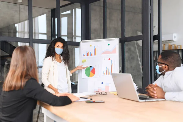 Multiracial colleagues wearing masks at the office