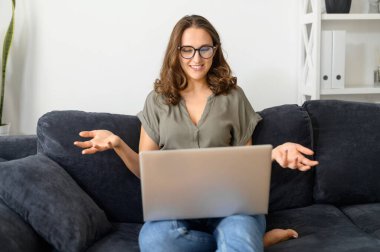 Video araması için dizüstü bilgisayar kullanan çekici kıvırcık kadın.