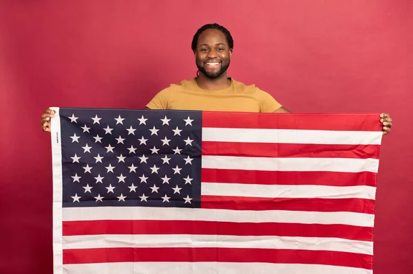 Smiled black muscular man holding american flag in front of him Royalty Free Stock Photos