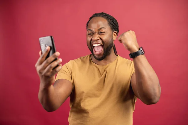 Känslomässigt porträtt av svart kille tittar på mobiltelefon — Stockfoto