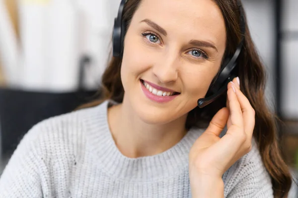 Video chat with young smiling woman wearing headset