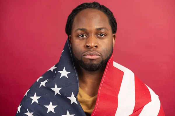 Nära porträtt av allvarlig svart man täckt med amerikansk flagga — Stockfoto