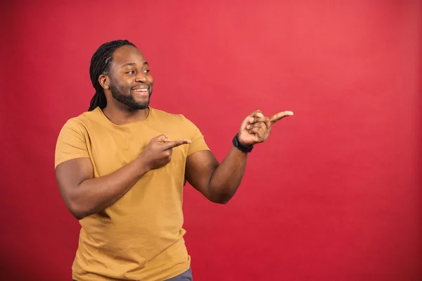 Positiv svart man ser ut och pekar åt sidan med båda pekfingrarna — Stockfoto