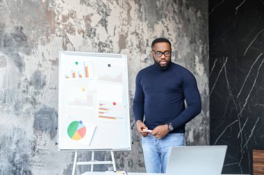 Kendine güvenen Afro-Amerikan adam elinde video webinar tutuyor.