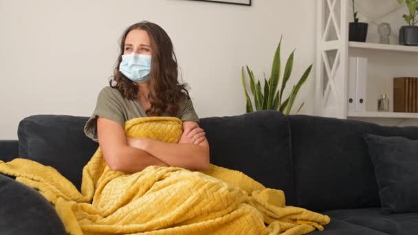 Mujer enferma joven con máscara protectora se siente mal en casa — Vídeo de stock