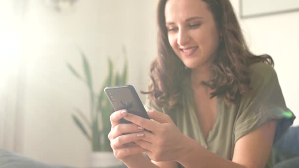 Vrolijke jonge vrouw met een smartphone — Stockvideo