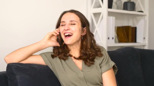 Mujer joven hilarante hablando por teléfono inteligente — Vídeo de stock