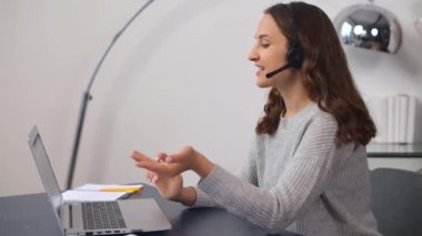 Kulaklık takmış gülümseyen genç satıcı, telefon konuşmasını yapıyor.