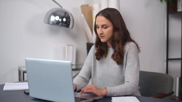 Pewna siebie młoda kobieta pracuje z laptopem w nowoczesnym biurze — Wideo stockowe