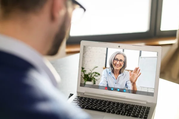 Sobre a foto do ombro do homem sentado no laptop — Fotografia de Stock