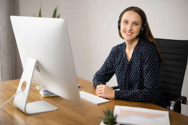 Mujer con auriculares trabaja en la oficina — Foto de Stock