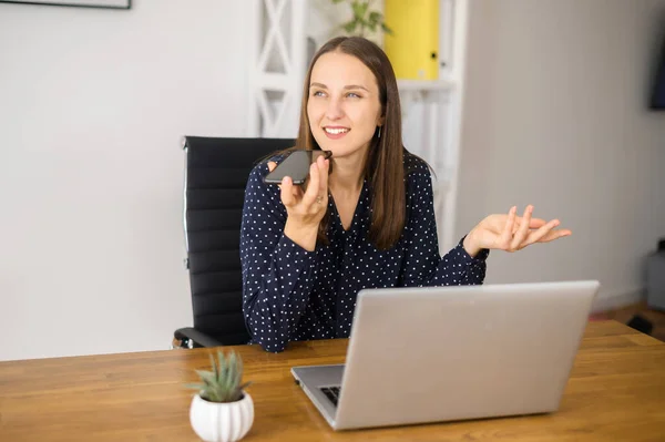 Junge Frau nimmt Sprachnachricht im Büro auf — Stockfoto