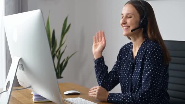 Kobieta używa zestawu słuchawkowego do komunikacji online — Wideo stockowe