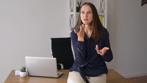 Zelfverzekerde jonge zakenvrouw met spraakherkenningsfunctie op een smartphone — Stockvideo