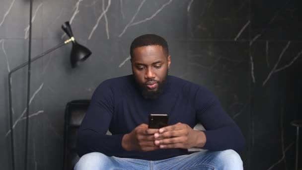 Empleado masculino afroamericano usando smartphone interior — Vídeos de Stock