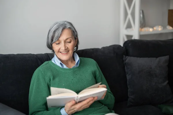 녹색 스웨터를 입고 책을 읽고 있는 할머니 — 스톡 사진