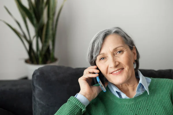 Старша леді розмовляє по телефону з дому — стокове фото