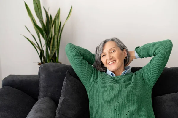 Encantadora señora mayor relajándose en el sofá — Foto de Stock