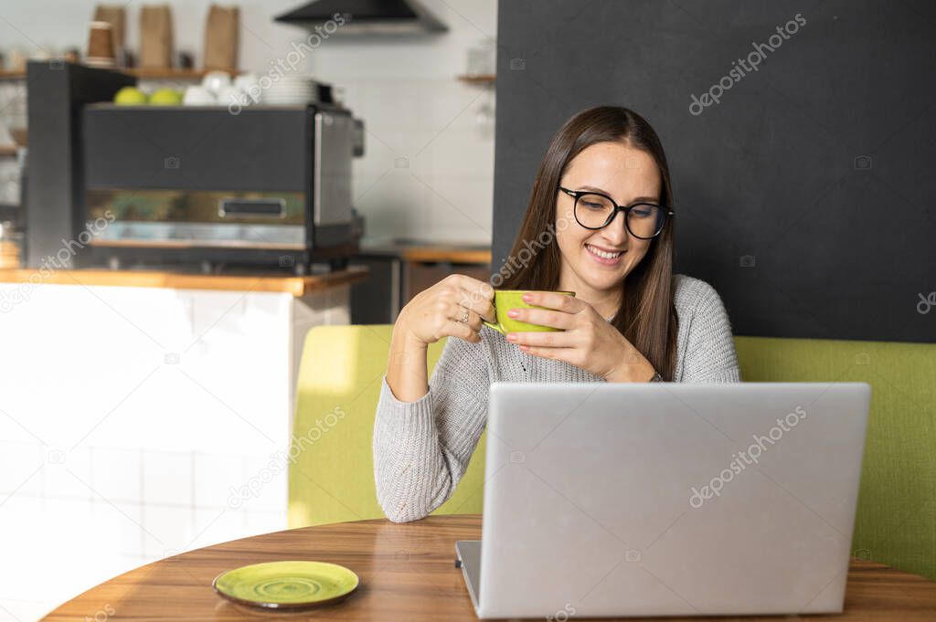Young woman with a laptop in the cafe
