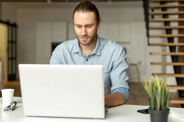 Chlap v elegantním neformálním oblečení používá notebook. — Stock fotografie