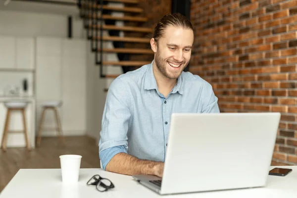 Un tipo con ropa casual inteligente está usando una computadora portátil — Foto de Stock