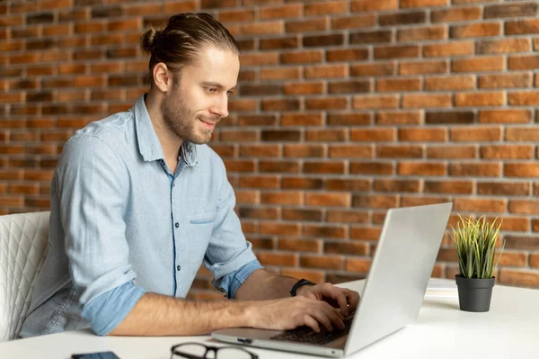 En kille i smart casual wear använder en bärbar dator — Stockfoto