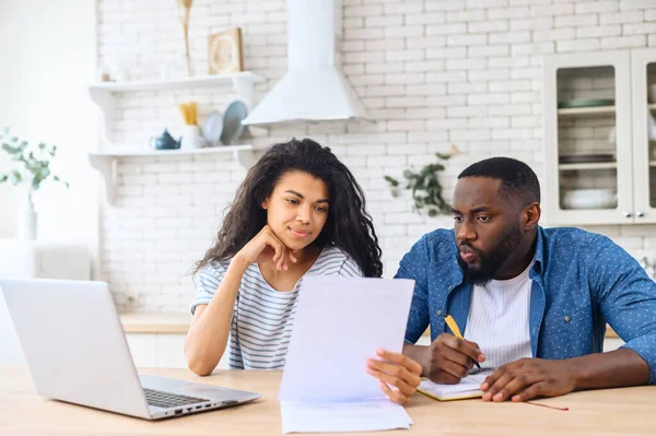 Pareja multirracial mirando a través de papeles — Foto de Stock