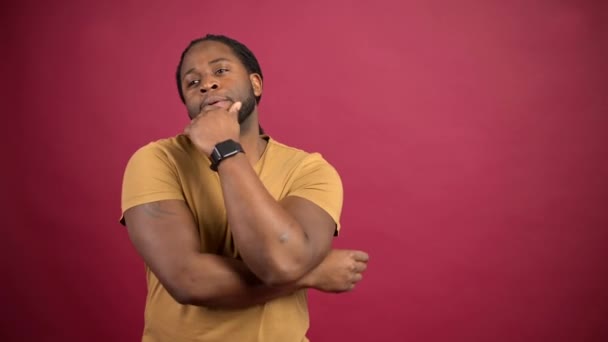 Zmatený afroameričan ve žlutém tričku izolovaný na červené — Stock video