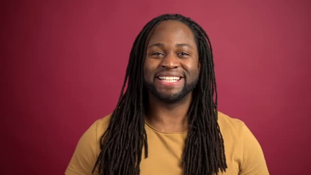 Cheerful African-American guy isolated on red background — Stock Video