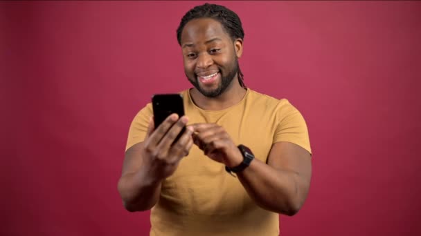 Jonge Afro-Amerikaanse man scrollen nieuwsfeed op mobiele telefoon — Stockvideo