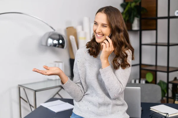 Gülümseyen kadın telefonda konuşuyor.